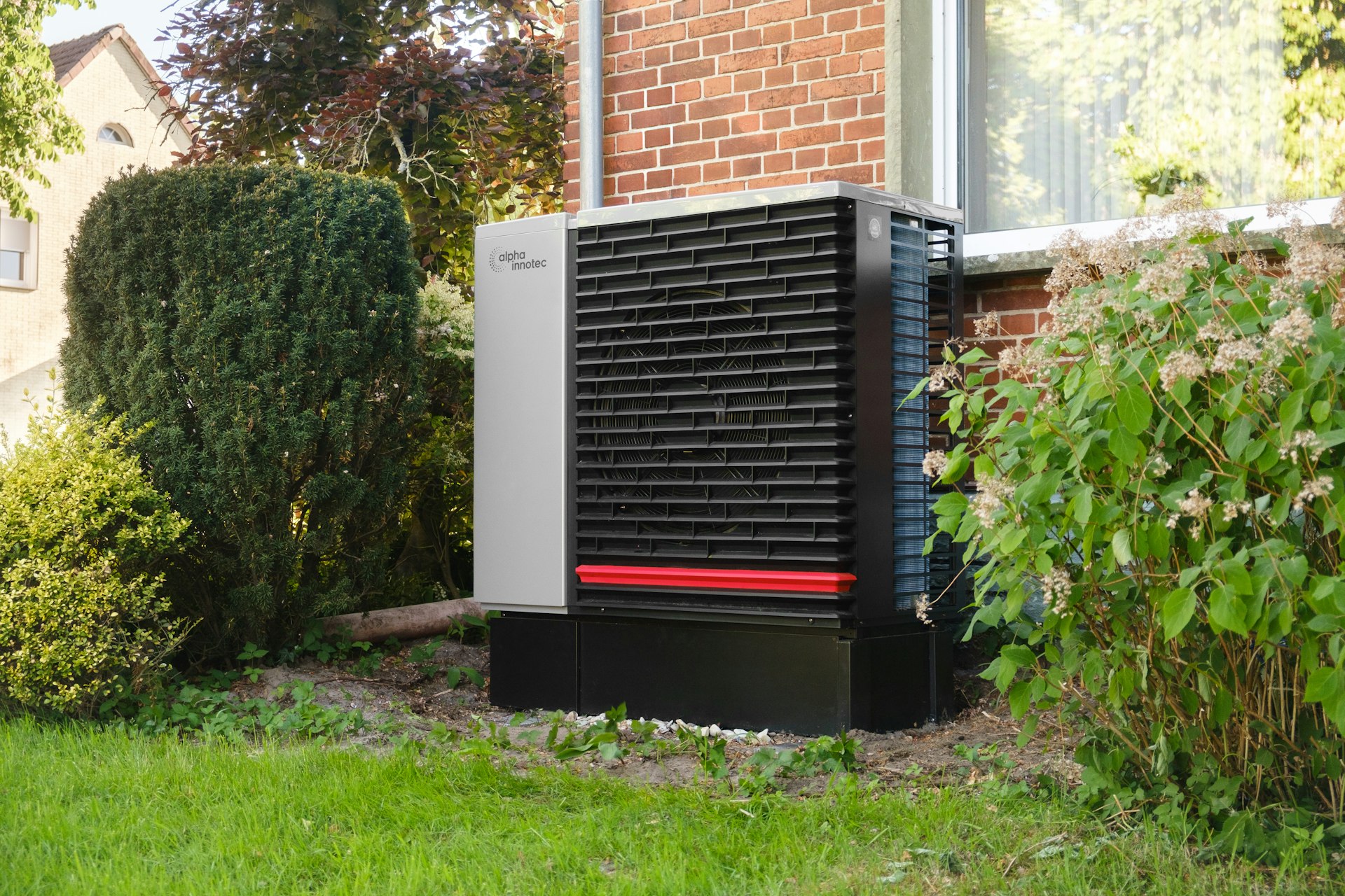 Pompe à chaleur air-eau installée contre le mur d'une maison en briques